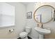 Stylish powder room features a round mirror, pedestal sink, and modern fixtures at 11985 Singing Winds St, Parker, CO 80138