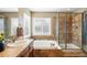 Elegant bathroom features a soaking tub, glass shower, and travertine tile at 11985 Singing Winds St, Parker, CO 80138