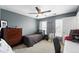 Bedroom boasts neutral carpet, a dark wood dresser, and natural light through windows at 11985 Singing Winds St, Parker, CO 80138