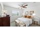 Cozy bedroom with ceiling fan, natural light, and a dresser with decorative lamps at 11985 Singing Winds St, Parker, CO 80138
