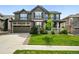 Traditional two-story home with a two-car garage, inviting curb appeal, and lush green lawn at 11985 Singing Winds St, Parker, CO 80138