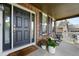 Inviting front porch with brick facade, seating area, and decorative plants at 11985 Singing Winds St, Parker, CO 80138