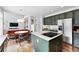 Open kitchen with eat-in nook, stainless appliances, modern lighting, and green cabinetry at 11985 Singing Winds St, Parker, CO 80138