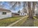 Landscaped backyard with a storage shed, mature tree, and path leading to the house at 5235 Dover St, Arvada, CO 80002