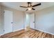 Bedroom shows wood floors, a ceiling fan and two doors, one open to the hallway with tile at 5235 Dover St, Arvada, CO 80002