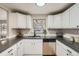 Bright kitchen features white cabinets, stainless steel appliances and modern countertops at 5235 Dover St, Arvada, CO 80002