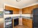 Kitchen featuring wooden cabinets, granite countertops, stainless steel appliances, and wood floors at 61 S Sable Blvd # C15, Aurora, CO 80012