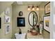 Bathroom with an oval mirror, copper sink and sage green walls at 432 N Ogden St, Denver, CO 80218