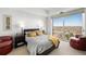 Light-filled main bedroom showcasing a large window with city views and cozy seating at 1900 E Girard Pl # 1103, Englewood, CO 80113