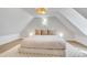 Cozy bedroom with pitched ceilings, decorative light fixture and a small stain-glass window at 748 Elati St, Denver, CO 80204