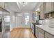 Contemporary kitchen with stainless steel appliances, light gray cabinets, and hardwood floors at 748 Elati St, Denver, CO 80204