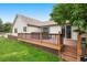 Back deck features stairs to the yard, wooden railings, and a hot tub for outdoor relaxation at 3461 Maple Cir, Brighton, CO 80601