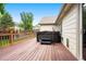 Spacious back deck features a hot tub and wooden railings with views of the backyard at 3461 Maple Cir, Brighton, CO 80601