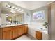 Bathroom featuring a double vanity, soaking tub, standing shower, and large mirror at 3461 Maple Cir, Brighton, CO 80601