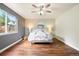 Inviting bedroom boasting a ceiling fan, neutral paint, modern decor, and a large window at 3461 Maple Cir, Brighton, CO 80601