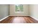Sunlit bedroom features stylish wood floors and a large window with neighborhood views at 3461 Maple Cir, Brighton, CO 80601