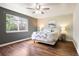 Cozy bedroom featuring a ceiling fan, modern decor, and a large window for natural light at 3461 Maple Cir, Brighton, CO 80601
