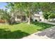 Well-maintained home with a manicured front lawn, mature trees, and inviting curb appeal at 3461 Maple Cir, Brighton, CO 80601