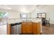 Kitchen with stainless steel appliances, modern sink, marble countertops, wood floors and open to dining room at 3461 Maple Cir, Brighton, CO 80601