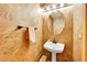 Charming powder room with textured walls, a pedestal sink, and decorative lighting at 766 Chimney Creek Dr, Golden, CO 80401