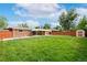 Expansive backyard with lush green grass, privacy fence, and covered patio, perfect for outdoor activities at 3216 Revere St, Aurora, CO 80011