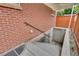 Exterior basement access with concrete stairs and brick wall at 3216 Revere St, Aurora, CO 80011
