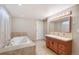 Bathroom featuring a jacuzzi tub, single sink vanity, and tiled flooring at 3216 Revere St, Aurora, CO 80011