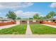 Charming single-story brick home featuring a well-manicured lawn and inviting walkway under a bright blue sky at 3216 Revere St, Aurora, CO 80011