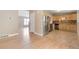Open-concept with hardwood floors leading to the kitchen with stainless steel appliances and wood cabinets at 3216 Revere St, Aurora, CO 80011
