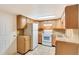 Functional kitchen featuring wooden cabinets, white appliances, and ample counter space at 3216 Revere St, Aurora, CO 80011