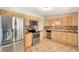 Fully-equipped kitchen with stainless steel appliances, wood cabinets and tiled floors offering both style and functionality at 3216 Revere St, Aurora, CO 80011