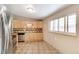Well-lit kitchen with stainless steel appliances, wood cabinets and tiled floors, ready for culinary adventures at 3216 Revere St, Aurora, CO 80011