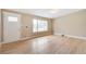 Bright living room featuring beautiful hardwood floors, a large window, and a welcoming front door at 3216 Revere St, Aurora, CO 80011