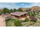 Aerial view of the house featuring a charming pond and natural landscaping at 5565 Osage Way, Larkspur, CO 80118