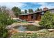Serene backyard with a charming pond, stone accents, and lush greenery at 5565 Osage Way, Larkspur, CO 80118