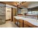 Bathroom featuring a dual sink vanity, wood accents and sliding door at 5565 Osage Way, Larkspur, CO 80118