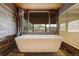 Bathroom featuring a soaking tub with wood accents and natural light at 5565 Osage Way, Larkspur, CO 80118