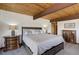 Cozy bedroom featuring a king-size bed and wood beam ceiling at 5565 Osage Way, Larkspur, CO 80118