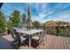 Relaxing outdoor deck with dining set and grill, perfect for enjoying scenic views at 5565 Osage Way, Larkspur, CO 80118