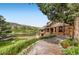 Beautiful home with stone accents, manicured gardens, and a scenic lakeside setting at 5565 Osage Way, Larkspur, CO 80118