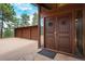 Inviting front entrance with a massive wooden door, sidelight window, and extra deep three-car garage at 5565 Osage Way, Larkspur, CO 80118