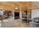 Open-concept living room with stone floors, wood ceiling and fireplace at 5565 Osage Way, Larkspur, CO 80118