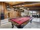 Large recreation room features a pool table, game machine, and access to other entertainment areas at 5565 Osage Way, Larkspur, CO 80118