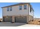 Two-story home featuring a stone facade, gray siding, and a two-car garage, providing ample space and curb appeal at 22385 E 6Th Ave, Aurora, CO 80018