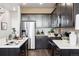 Modern kitchen with dark cabinets, stainless steel appliances, white countertops and a stylish backsplash at 22385 E 6Th Ave, Aurora, CO 80018