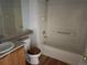 Bathroom featuring a sink, a toilet, wood floors, and a bathtub with shower and tile surround at 1216 S Flat Rock Cir, Aurora, CO 80018