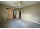 Bedroom featuring neutral carpet and walls, as well as a barn door to the bathroom at 1216 S Flat Rock Cir, Aurora, CO 80018