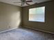 Neutral bedroom featuring wall-to-wall carpeting, a ceiling fan, and a large window bringing in natural light at 1216 S Flat Rock Cir, Aurora, CO 80018