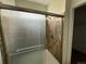 Shower featuring a glass door, stone-look tile, and dual shower head at 1216 S Flat Rock Cir, Aurora, CO 80018