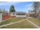 Backyard view featuring green grass, mulch, and a brick pathway leading to the house at 903 Poplar St, Denver, CO 80220